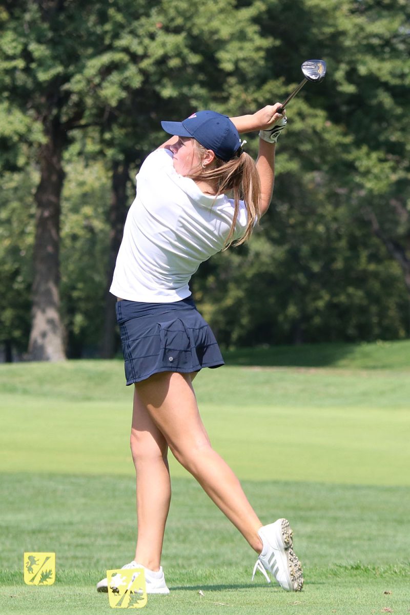 With full force, sophomore Lola Dumler swings her club. 
